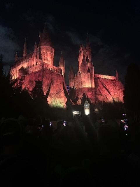 The image shows an illuminated view of Hogwarts Castle at night, from the Harry Potter series