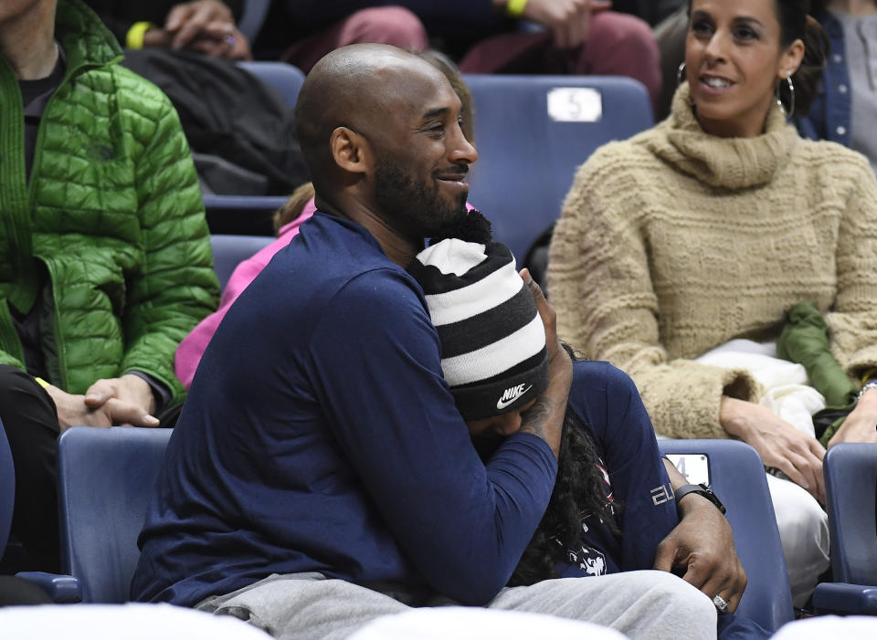 Kobe Bryant and his daughter Gianna watch the first half of an NCAA college basketball game between Connecticut and Houston, Saturday, March 2, 2019, in Storrs, Conn. (AP Photo/Jessica Hill)