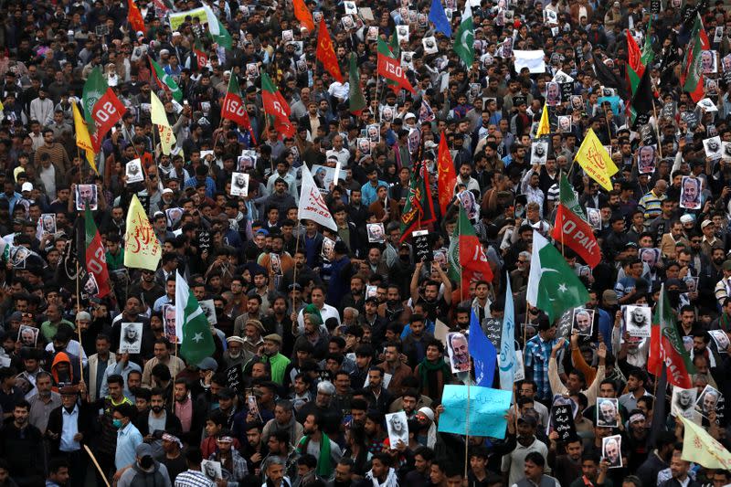 Pakistani Shi'ite Muslims carry flags and signs to protest the death of Iranian military commander Qassem Soleimani, who was killed in a airstrike near Baghdad, as they march on a road leading towards the U.S. consulate in Karachi