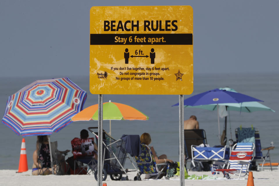 FILE - In this Monday, May 4, 2020 file photo, visitors sunbathe after the beach officially reopened to the public in Clearwater Beach, Fla., after coronavirus restrictions were lifted. The pandemic caught fire in Florida this summer as the state's rapid reopening allowed people to flock to beaches, Disney World, movie theaters and bars. (AP Photo/Chris O'Meara)