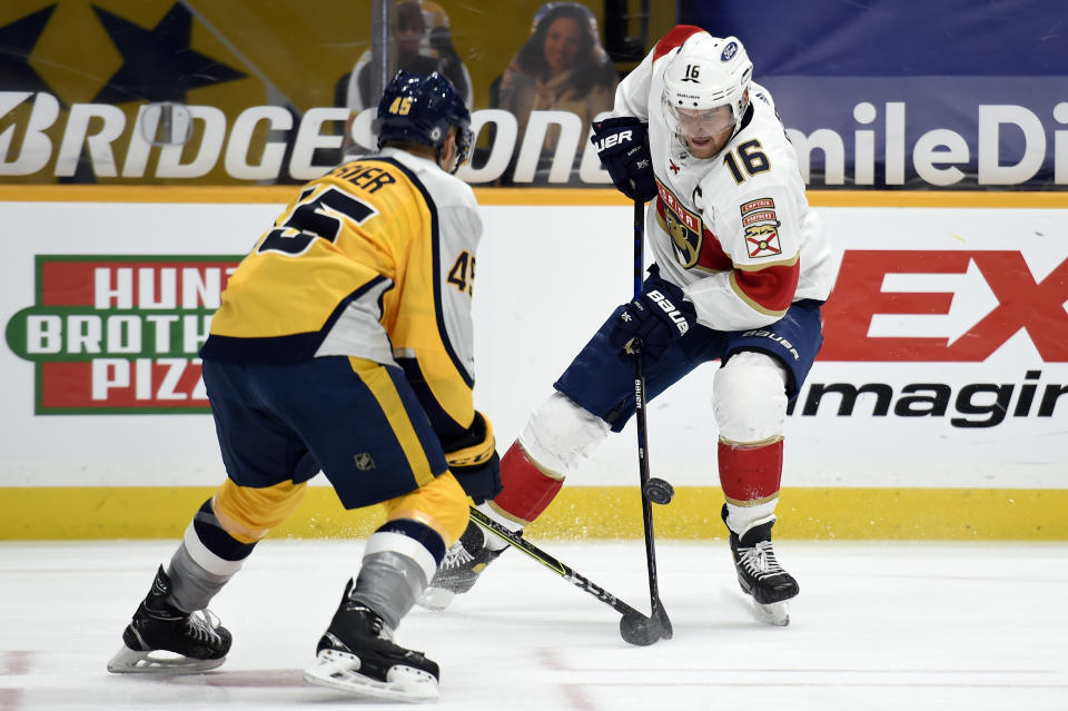 Florida Panthers center Aleksander Barkov (16) tries to get control of the puck as he is defended by Nashville Predators defenseman Alexandre Carrier (45) during the first period of an NHL hockey game Saturday, March 6, 2021, in Nashville, Tenn. (AP Photo/Mark Zaleski)