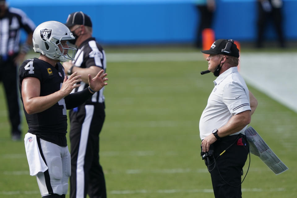 Las Vegas Raiders head coach Jon Gruden talks with quarterback Derek Carr during the second half of an NFL football game against the Carolina Panthers Sunday, Sept. 13, 2020, in Charlotte, N.C. (AP Photo/Brian Blanco)
