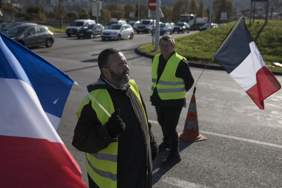 Protesters gather at a traffic circle during a yellow vest demonstration marking the one year anniversary of the movement in Marseille, southern France, Saturday, Nov. 16, 2019. Police are deployed around key sites in Paris as France's yellow vest protesters prepare to mark the first anniversary of their sometimes-violent movement for economic justice. (AP Photo/Daniel Cole)