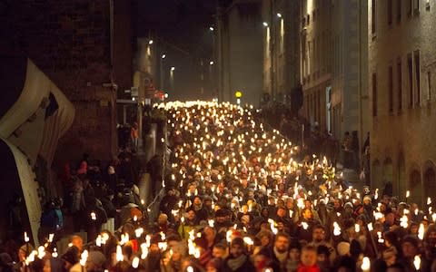 The Torchlight Procession which marks the opening of city's New Year celebrations, makes its way through Edinburgh - Credit:  David Cheskin/PA