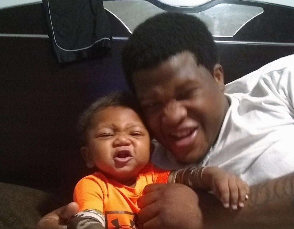 This photo provided by Avontea Boose shows her baby Tristan Roberson and the boy's father Jemel Roberson. A police officer fatally shot Jemel Roberson, an armed security guard who was wearing a hat with "security" emblazoned across the front and holding a man down following a shooting inside the suburban Chicago bar where the guard worked, an attorney for the guard's family said Monday, Nov. 12, 2018, after filing a federal lawsuit. (Avontea Boose via AP)