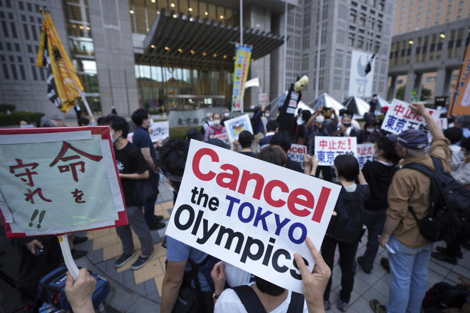 FILE - In this June 23, 2021, file photo, people against the July opening of the Tokyo 2020 Olympics, gather to protest around the Tokyo Metropolitan Government building during a demonstration in Tokyo. From doping, to demonstrations to dirty officials, the Olympics have never lacked their share of off-the-field scandals and controversies that keep the Games in the headlines long after the torch goes out. (AP Photo/Eugene Hoshiko, File)