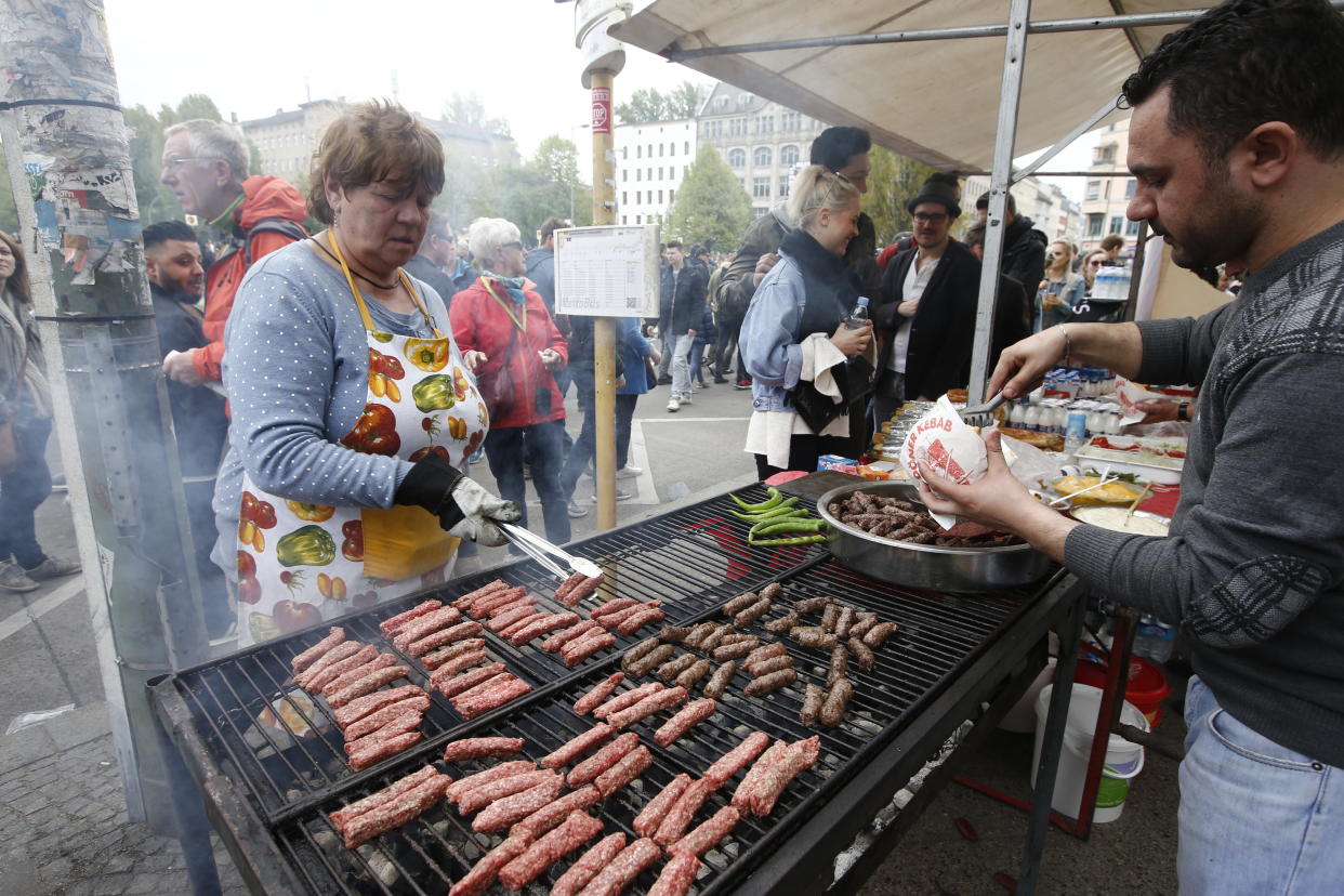 A woman grills sausages at the traditional MyFest street festival in Berlin's Kreuzberg district, Berlin , Germany, May 1, 2017. REUTERS/Fabrizio Bensch