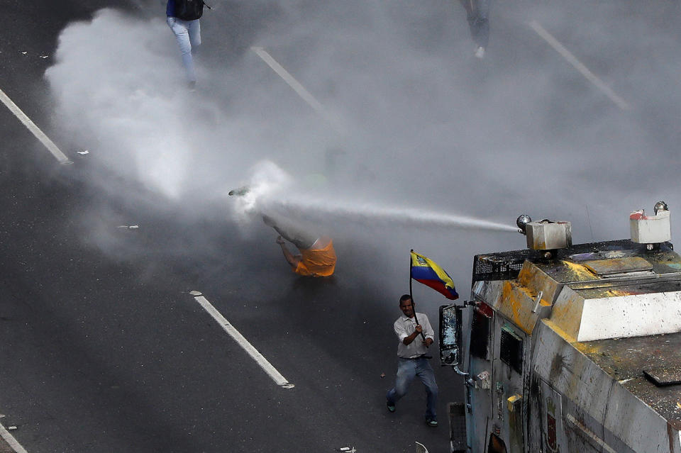 <p>Opposition Deputy Carlos Paparoni is hit by a jet of water during clashes at a march to the state ombudsman’s office in Caracas, Venezuela, May 29, 2017. (Carlos Garcia Rawlins/Reuters) </p>