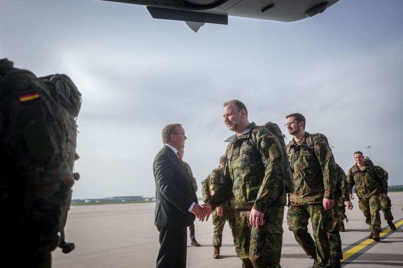 German Minister of Defense Boris Pistorius (L) bids farewell to the pre-commando of the Lithuanian brigade at the military section of Berlin-Brandenburg Airport. The army inspector will then fly to Lithuania with his soldiers in an Airbus A400M. Kay Nietfeld/dpa