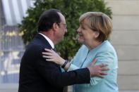 French President Francois Hollande (L) welcomes German Chancellor Angela Merkel before talks and a dinner at the Elysee Palace in Paris, France, July 6, 2015. REUTERS/Philippe Wojazer