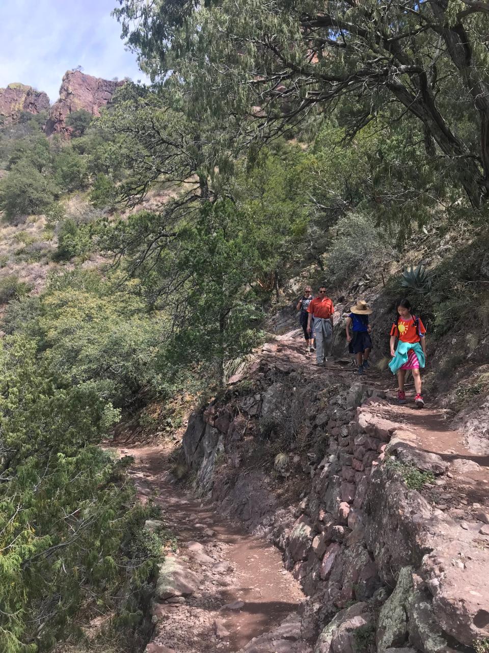 Hikers move down the switchbacks on the Lost Mine Trail in Big Bend National Park, Texas. The trail, constructed by members of the Civilian Conservation Corps (CCC) in the early 1940s, shows evidence of their skilled craftsmanship in the stonework. It weaves through juniper, oak and pine forest.