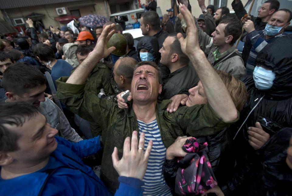 A man cries after being released from a local police station which was stormed by pro-Russian protesters in Odessa, Ukraine, Sunday, May 4, 2014. Several prisoners that were detained during clashes that erupted Friday between pro-Russians and government supporters in the key port on the Black Sea coast were released under the pressure of protesters that broke into a local police station and received a hero's welcome by crowds. (AP Photo/Vadim Ghirda)