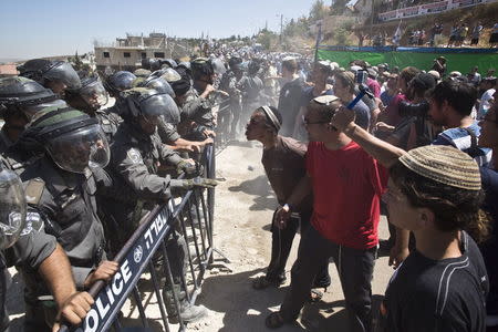 Israeli paramilitary police (L) stand in front of Jewish settlers protesting the demolition of two partially-built dwellings in the West Bank Jewish settlement of Beit El near Ramallah July 29, 2015. REUTERS/Emil Salman