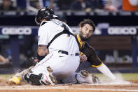 San Diego Padres' Eric Hosmer, right, is tagged out at the plate by Miami Marlins catcher Sandy Leon during the second inning of a baseball game, Sunday, July 25, 2021, in Miami. (AP Photo/Lynne Sladky)