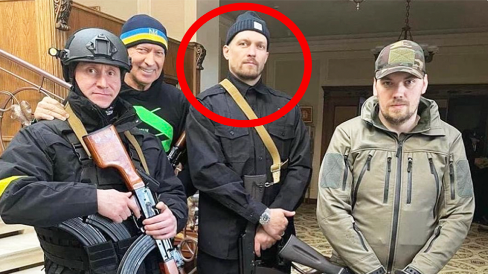 Boxing champ Oleksandr Usyk (pictured second right) posing for a photo in military gear in Ukraine.