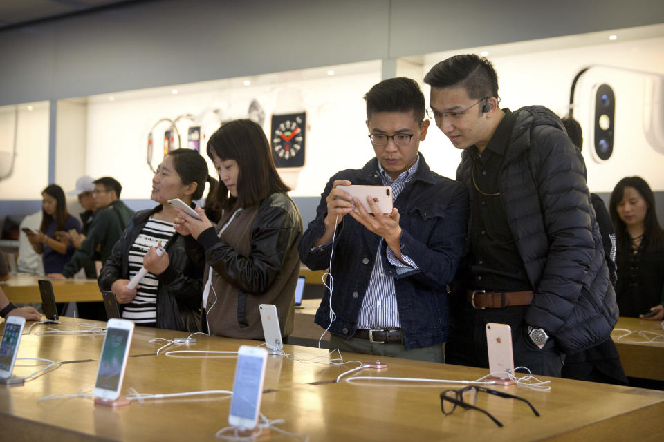 Customers try out iPhones as they shop at an Apple Store in Beijing, China, Friday, Oct. 20, 2017. (AP Photo/Mark Schiefelbein)