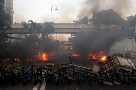 Anti-government protesters set a fire to form a barricade in Sha Tin, Hong Kong
