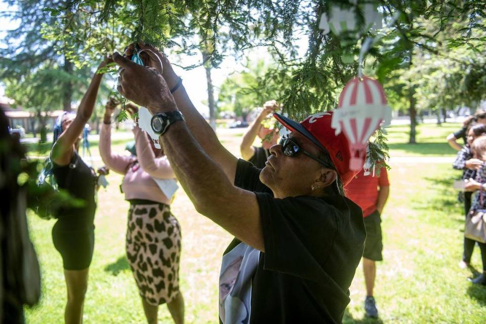 Raul Garcia, 54, of Merced, hangs a paper balloon with a message to his stepson Aaron Albert Jimenez during the Merced County Victims’ Rights Ceremony at Courthouse Park in Merced, Calif., on Tuesday, April 25, 2023. Jimenez was 41-years-old when he was shot and killed with an air rifle in Merced on Dec. 11, 2022. The annual event held to remember victims of violence and crime, is hosted by the Merced County District Attorney’s Office during National Crime Victims’ Rights Week.