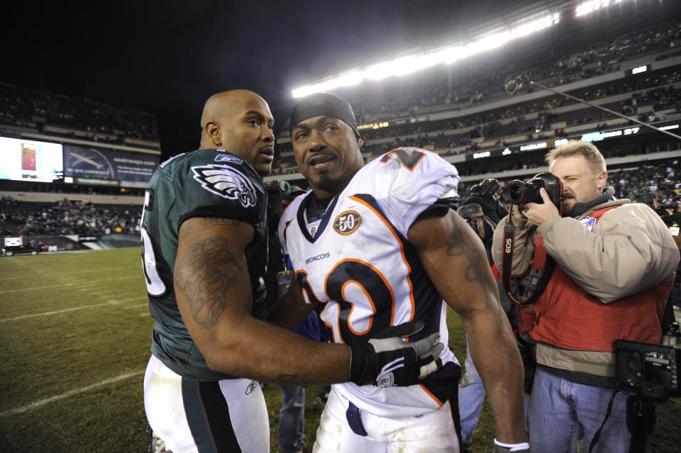 FILE - Philadelphia Eagles defensive end Juqua Parker (75) and Denver Broncos safety Brian Dawkins (20) meet on the field at the end of an NFL football game in Philadelphia, in this Sunday, Dec. 27, 2009, file photo. Dawkins, the seven-time Pro Bowl safety in 13 seasons in Philadelphia, returned as a Bronco in 2009. He hugged former teammates after the game and blew kisses to the fans as he ran off the field following a 30-27 loss. (AP Photo/Michael Perez, File)