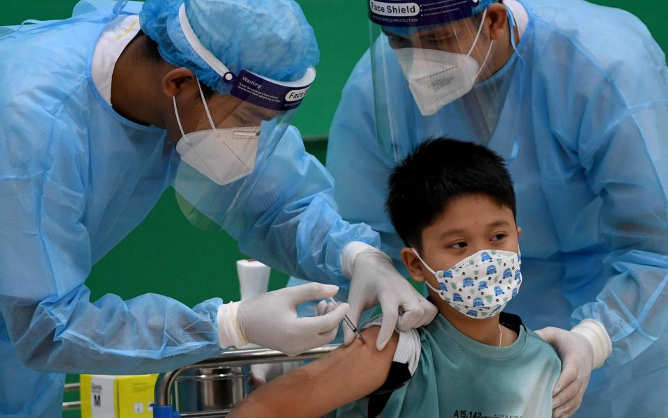 The grandson of Cambodia's Prime Minister Hun Sen receives a dose of the Sinovac Covid-19 coronavirus vaccine at the Peace Palace in Phnom Penh on September 17 - TANG CHHIN SOTHY/AFP