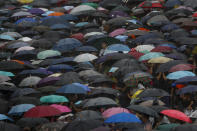 Protesters with umbrellas brave the rain during a rally in Hong Kong Sunday, Aug. 18, 2019. People are streaming into a park in central Hong Kong for what organizers hope will be a peaceful demonstration for democracy in the semi-autonomous Chinese territory. (AP Photo/Vincent Thian)