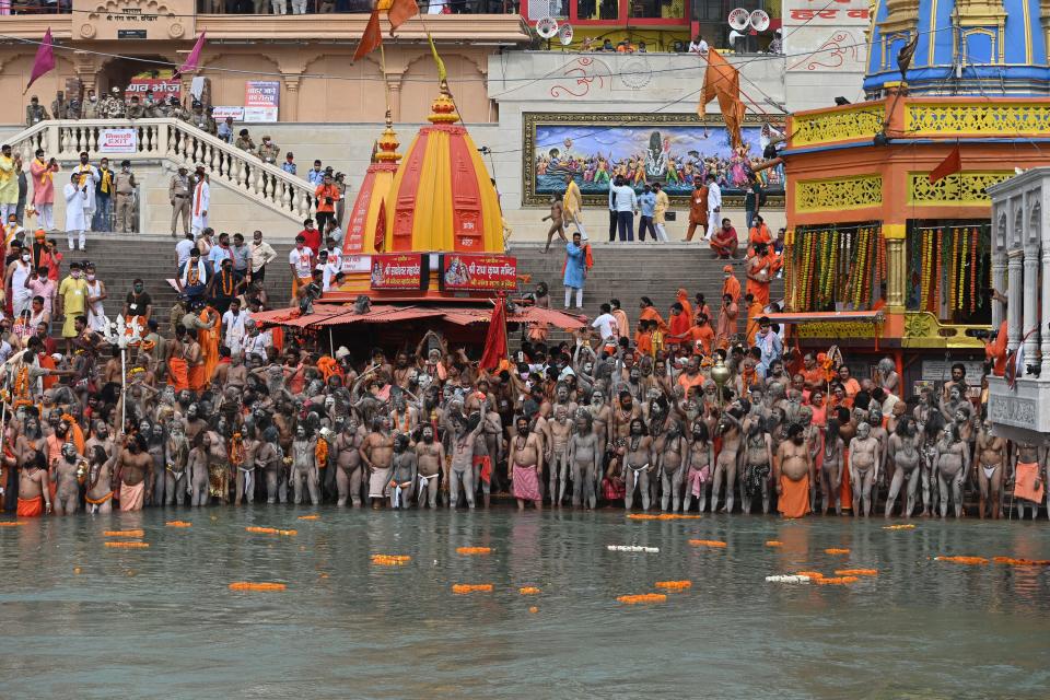 Naga Sadhus (Hindu holy men) take a holy dip in the waters of the Ganges River on the day of Shahi Snan (royal bath) during the ongoing religious Kumbh Mela festival, in Haridwar on April 12, 2021. (Photo by Money SHARMA / AFP) (Photo by MONEY SHARMA/AFP via Getty Images)