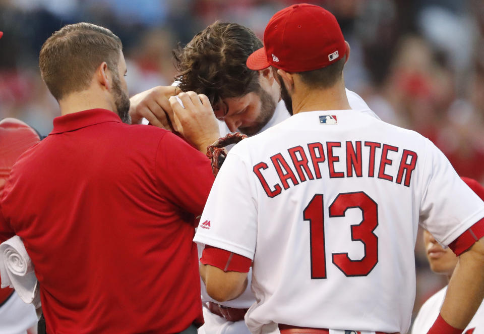 St. Louis Cardinals starting pitcher Lance Lynn is checked on by Cardinals trainer Adam Olsen after being hit in the head by a line drive. (AP Photo)