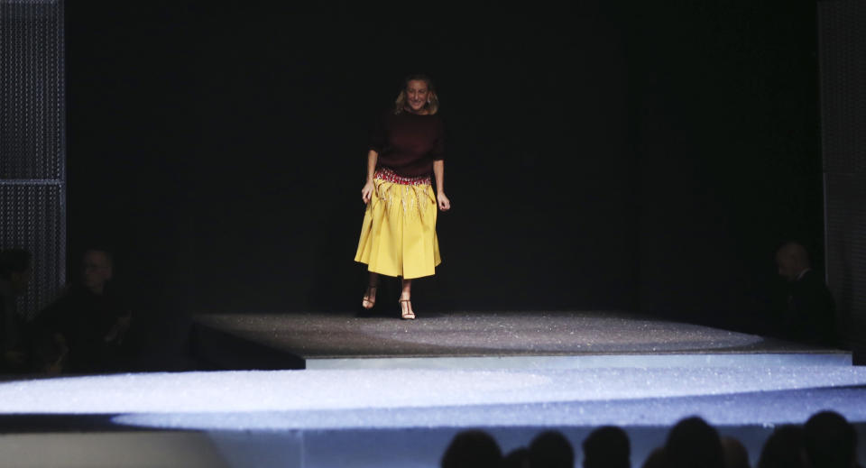 Italian fashion designer Miuccia Prada bows to the audience after presenting the Prada men's Fall-Winter 2014 fashion show, part of the Milan Fashion Week, unveiled in Milan, Italy, Sunday, Jan.12, 2014. (AP Photo/Luca Bruno)