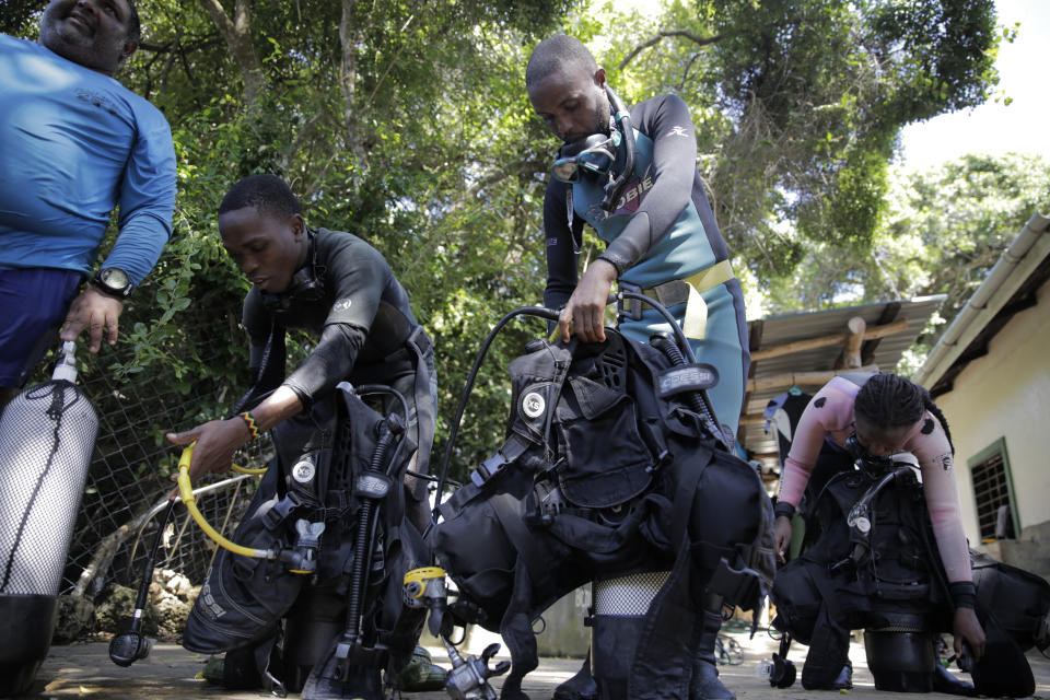 Coral reef restoration rangers prepare to go dive and put artificial reef structures in the Indian Ocean in Shimoni, Kenya on Monday, June 13, 2022. The marine area off the coast of Kenya at Wasini Island, jointly managed by a foundation and the island's community, has been planting over 8,000 corals a year since 2010 and placed about 800 artificial reef structures in the channel in a bid to restore Wasini's coral gardens. (AP Photo/Brian Inganga)