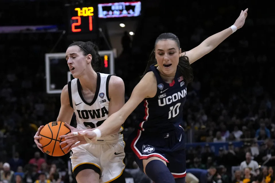 UConn guard Nika Muhl (10) tries to steal the ball from Iowa guard Caitlin Clark during the second half of a Final Four college basketball game in the women's NCAA Tournament, Friday, April 5, 2024, in Cleveland. (AP Photo/Carolyn Kaster)