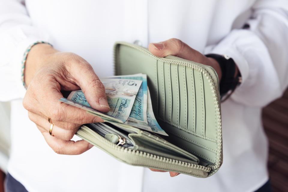 Close up of hand of woman taking out pounds from her purse