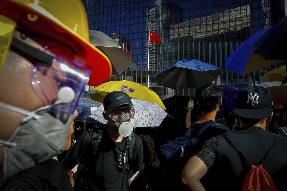 Protesters wearing protective gear gather outside the Legislative Council in Hong Kong, Monday, July 1, 2019. Combative protesters tried to break into the Hong Kong legislature Monday as a crowd of thousands prepared to start a march in that direction on the 22nd anniversary of the former British colony's return to China. (AP Photo/Vincent Yu)