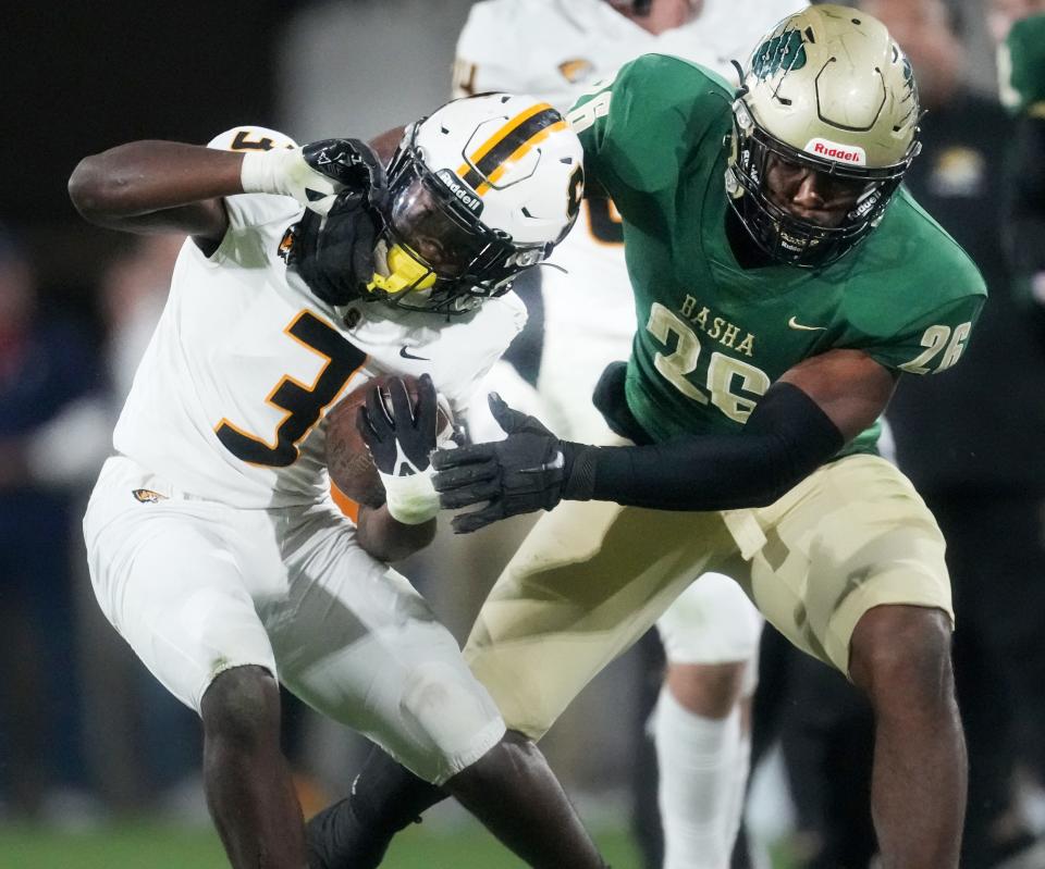 Saguaro running back Jaedon Matthews (3) is dragged down by Basha defensive end Jordan Howard (26) during their Open Division State Championship at ASU Sun Devil Stadium in Tempe on Dec. 10, 2022.