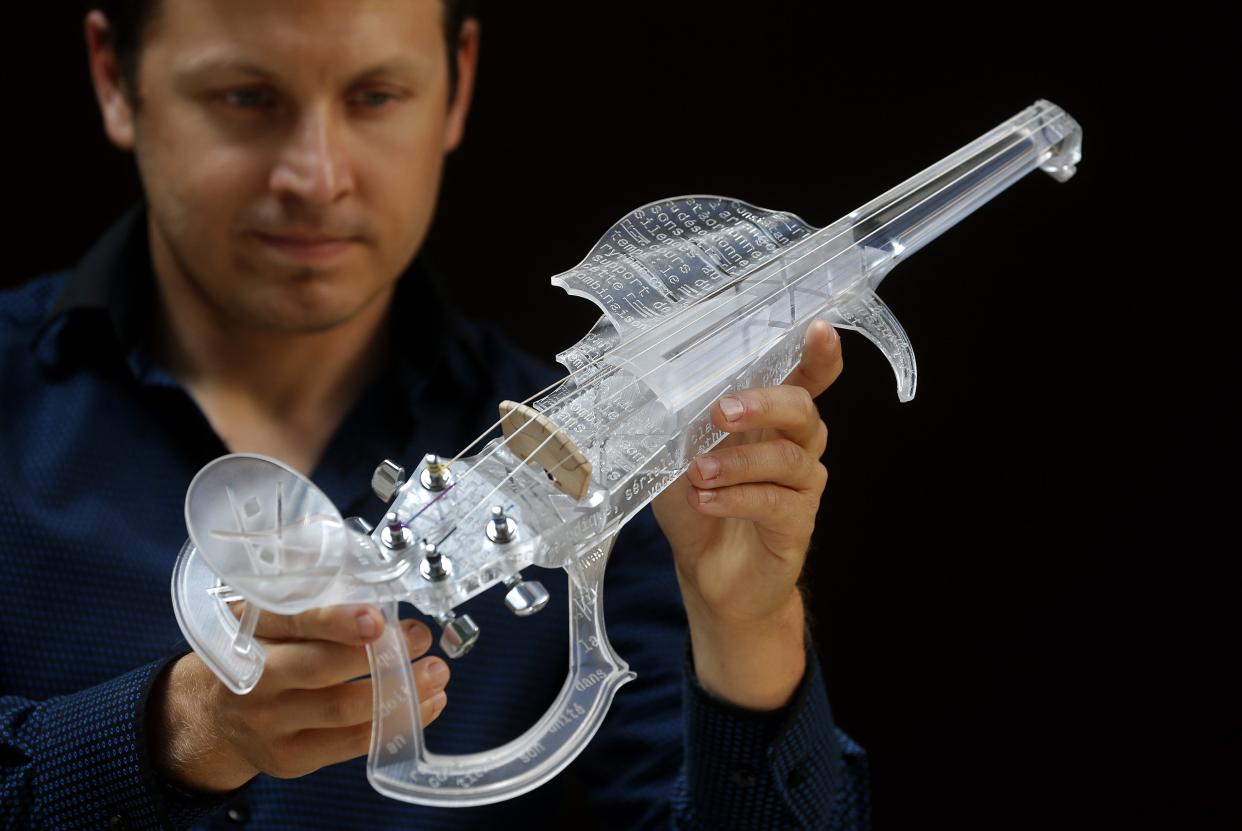 French engineer and professional violinist Laurent Bernadac poses with the “3Dvarius.” REUTERS/Christian Hartmann