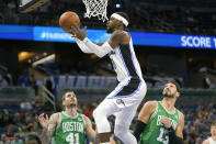 Orlando Magic's Terrence Ross, center, makes a shot as he gets between against the Boston Celtics' Juancho Hermangomez (41) and Enes Kanter, right, during the first half of an NBA preseason basketball game, Wednesday, Oct. 13, 2021, in Orlando, Fla. (AP Photo/John Raoux)