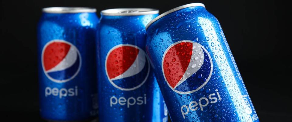 Cans of Pepsi with water drops on black table