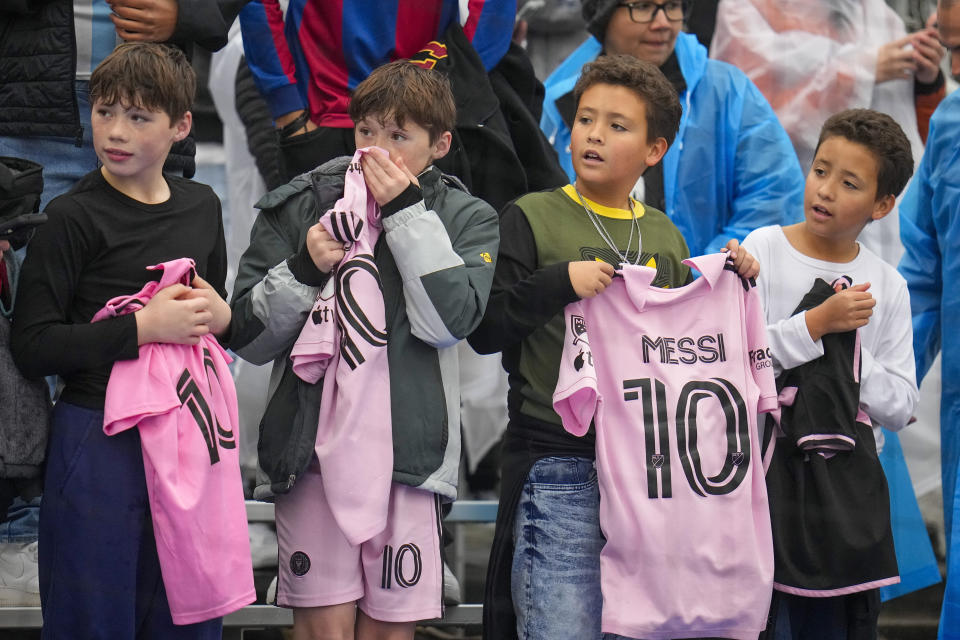 Supporters of Inter Miami's Lionel Messi hold his jersey as they wait for players to warm up prior to a preseason friendly MLS soccer match between FC Dallas and Inter Miami Monday, Jan. 22, 2024, at the Cotton Bowl in Dallas. (AP Photo/Julio Cortez)
