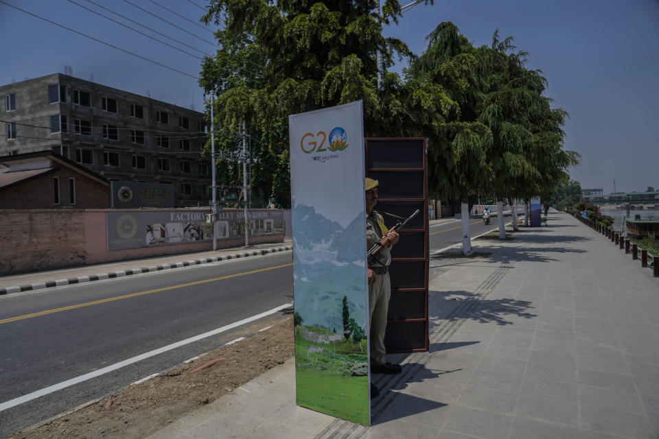 An Indian policeman guards behind a temporary security post as delegates from the Group of 20 nations arrive to participate in a tourism meeting in Srinagar, Indian controlled Kashmir, Monday, May 22, 2023. The meeting scheduled for later Monday is the first significant international event in Kashmir since New Delhi stripped the Muslim-majority region of semi-autonomy in 2019. (AP Photo/Mukhtar Khan)