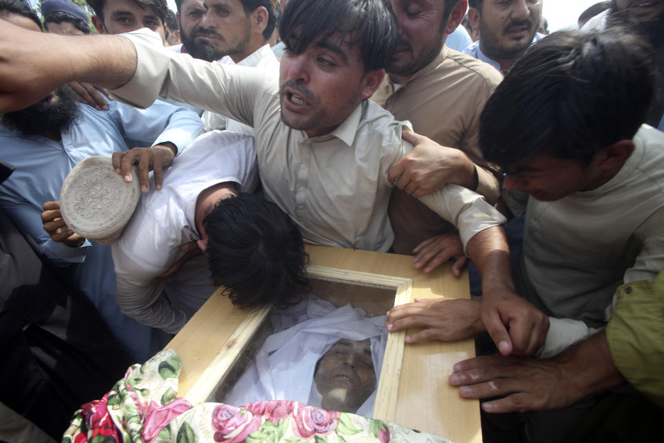 Family members and relatives mourn as they gather around the casket of a victim who was killed in Sunday's suicide bomber attack in the Bajur district of Khyber Pakhtunkhwa, Pakistan, Monday, July 31, 2023. Pakistan held funerals on Monday for victims of a massive suicide bombing that targeted a rally of a pro-Taliban cleric the previous day. (AP Photo/Mohammad Sajjad)