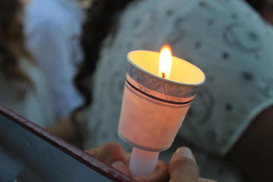 Family members and friends of four women who authorities say were killed by a U.S. Border Patrol agent attend a candlelight vigil at a park in downtown Laredo, Texas, on Tuesday, Sept. 18, 2018. Juan David Ortiz was arrested Saturday while hiding in a hotel parking garage. Investigators believe he fatally shot the four victims during separate attacks after taking each of them to desolate areas outside of Laredo. Investigators say a fifth victim escaped and contacted authorities. (AP Photo/Susan Montoya Bryan)