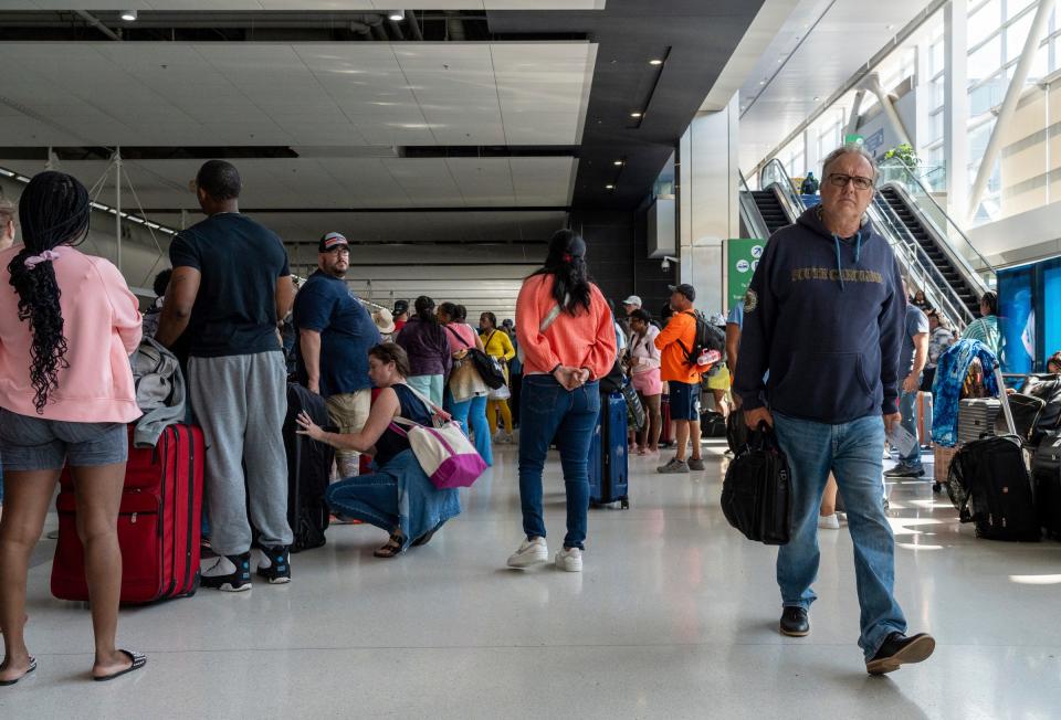 Travelers make their way through a crowded check-in area of the Evans Terminal early in the morning at Detroit Metro Airport on Friday, July 19, 2024.