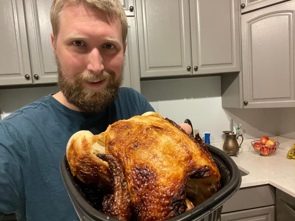The writer holds a rotisserie chicken from Meijer