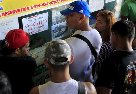 Stranded passengers gather at a ticketing booth with a note announcing the cancellation of bus trips due Typhoon Noul, locally name Dodong, at a bus terminal in Manila May 9, 2015 . REUTERS/Romeo Ranoco