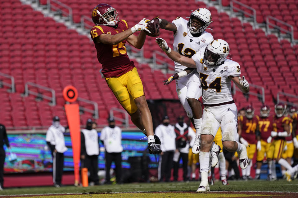 CORRECTS TO SECOND HALF, NOT FIRST HALF - Southern California wide receiver Drake London (15) catches a pass in the end zone for a touchdown as Arizona State defensive back Kejuan Markham (12) and linebacker Kyle Soelle (34) defend during the second half of an NCAA college football game Saturday, Nov. 7, 2020, in Los Angeles. USC won 28-27. (AP Photo/Ashley Landis)