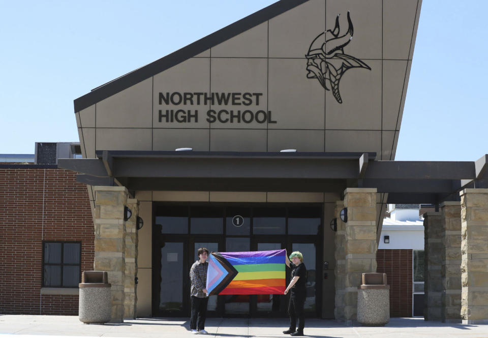 Former Viking Saga newspaper staff members Marcus Pennell, left, and Emma Smith, right, display a pride flag outside of Northwest High School in Grand Island, Neb., July 20, 2022. Administrators of a Nebraska public school have shuttered the school’s award-winning student newspaper, just days after its last edition that included articles and editorials on LGBTQ issues. (McKenna Lamoree/The Independent via AP)