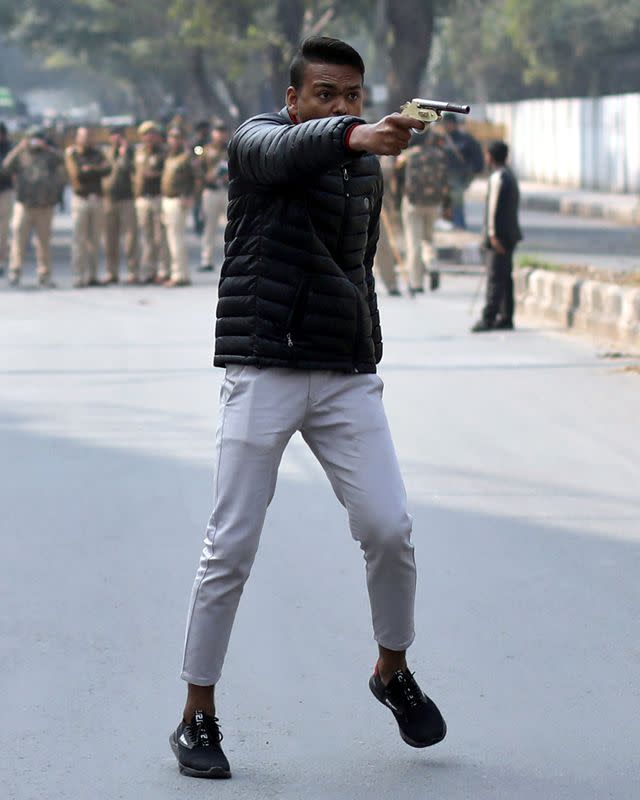 Man brandishes a gun during a protest against a new citizenship law outside the Jamia Millia Islamia university in New Delhi