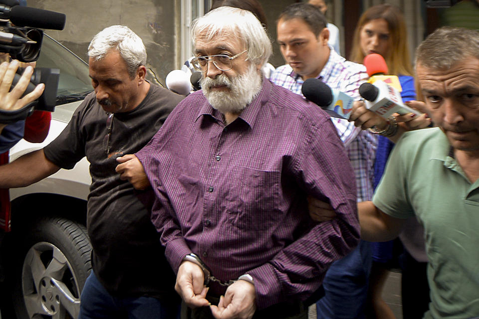 Romanian guru Gregorian Bivolaru is escorted to a vehicle, after a hearing at the Romanian Police headquarters in Bucharest, Romania, Wednesday, Aug. 24, 2016. French authorities arrested the leader of a multinational tantric yoga organization Tuesday Nov. 28, 2023 on suspicion of indoctrinating female followers for sexual exploitation. The Romanian guru at the heart of the Atman Yoga Federation was detained during a massive morning police operation across the Paris region. (AP Photo/Marian Ilie)