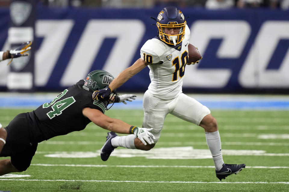 Toledo wide receiver Adam Beale (10) pulls away from Ohio linebacker Dylan Stevens (34) during the second half of the Mid-American Conference championship NCAA college football game, Saturday, Dec. 3, 2022, in Detroit. (AP Photo/Carlos Osorio)