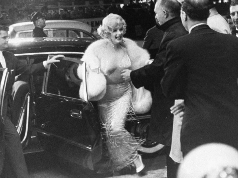 Marilyn Monroe (C) emerging from limo upon arrival at premiere of her new film Some Like It Hot in Times Square