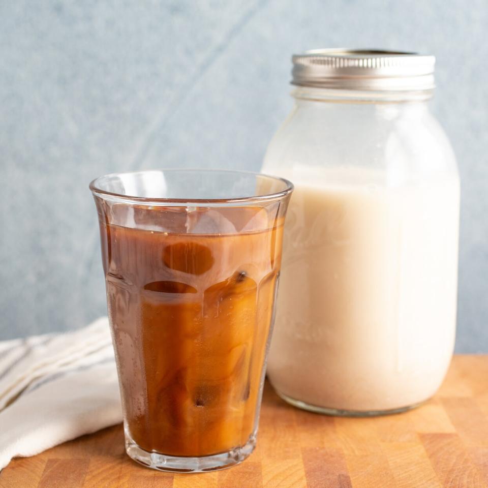 A coffee with oat milk and a jar of homemade oat milk